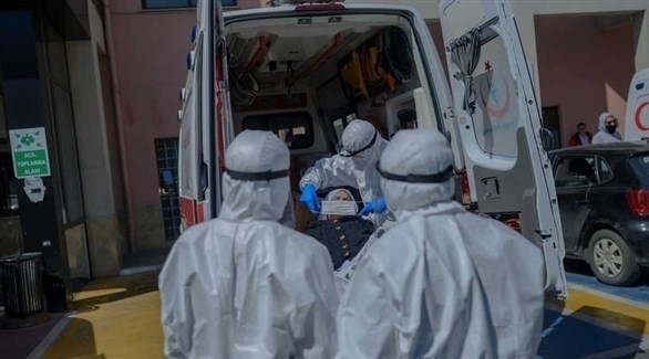 مسعفون أتراك يساعدون مصابةً بكورونا في سيارة إسعاف (الحرة)