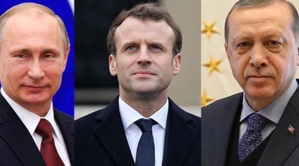 الرئيس الفرنسي إيمانويل ماكرون وسط الرئيسين التركي رجب طيب أردوغان والروسي فلاديمير بوتين (أرشيف)