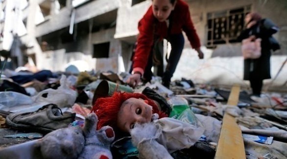 فتاة تبحث بين مقتنيات متروكة في مخيم اليرموك (أرشيف / أ ف ب)