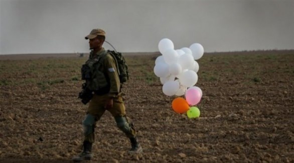 جندي إسرائيلي يسير قرب بالون أطلق من غزة (أرشيف)