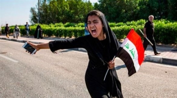 متظاهرة عراقية ترفع علم بلادها تنديد بالطبقة السياسية في بلادها (أرشيف)