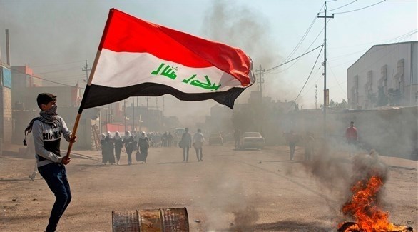 متظاهر يحمل العلم العراقي (أ ف ب)