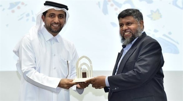 الأستاذ الأسترالي لقمان طالب يتسلم شهادة تقدير من مسؤول بجامعة قطر في 2018 (غارديان)
