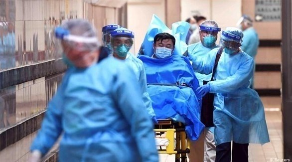 فريق طبي صيني يرافق مصاباً بفيروس كورونا (أرشيف)