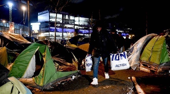 المهاجرون يغادرون المخيم الفرنسي (أ ف ب)