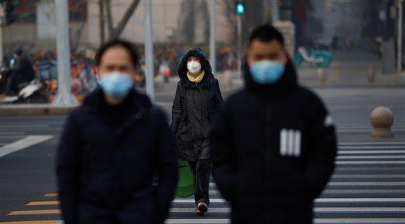 صينيون يرتدون كمامات خوفاً من عدوى كورونا (رويترز)