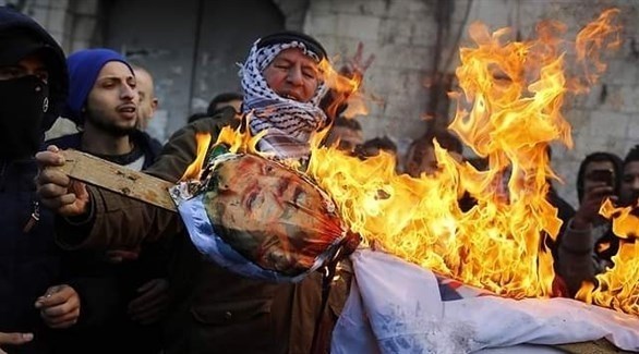 فلسطينيون يحرقون صورة ترامب في الضفة الغربية رفضاً لصفقة القرن (تويتر)