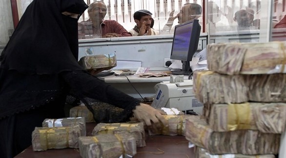 يمنية تعد رزماً مالية من الريالات اليمنية في أحد المصارف (أرشيف)