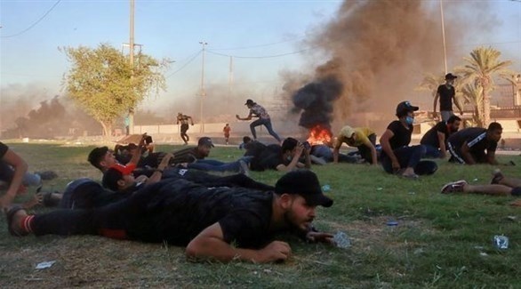 محتجون عراقيون على الأرض خوفاً من الإصابة بالرصاص في الاحتجاجات (أرشيف)
