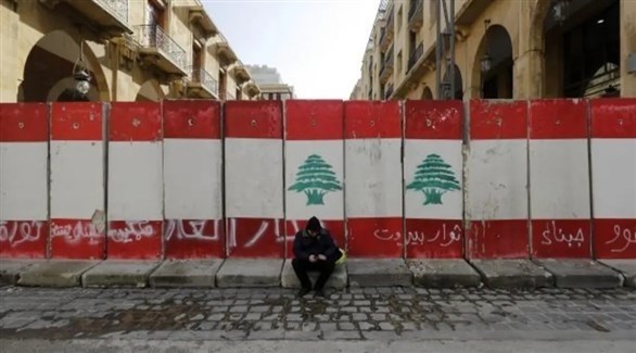 متظاهر يقف قبالة جدار يحمل العلم اللبناني وسط بيروت (أرشيف)
