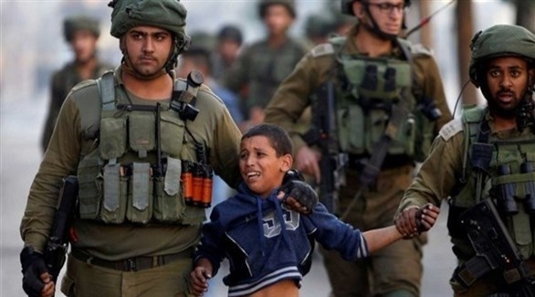 عناصر من الشرطة الإسرائيلية تعتلق طفلاً فلسطينياً (أرشيف)