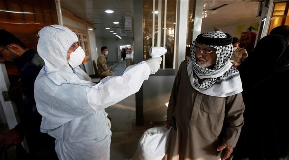 موظف صحي يعايد درجة حرارة مواطن عراقي.(أرشيف)