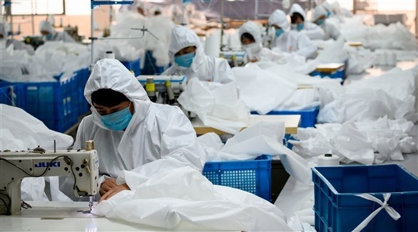 عمال يصنعون البذات الصحية في الصين (أ ف ب)