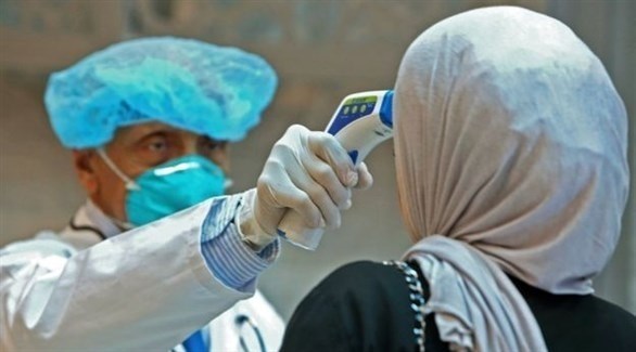 موظف من الصحة الكويتية يتأكد من حرارة سيدة في مدينة الكويت (أرشيف)