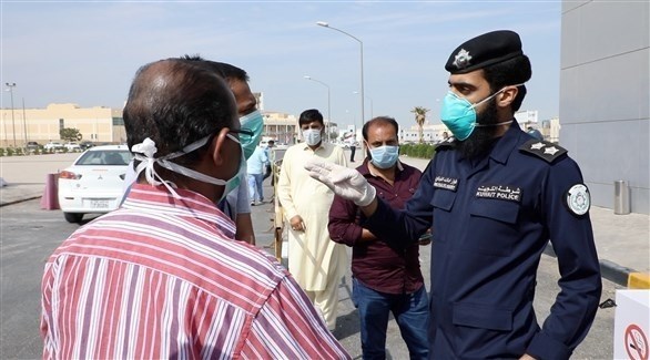 عنصر من الشرطة الكويتية متحدثاً لمجموعة من السكان (أرشيف)