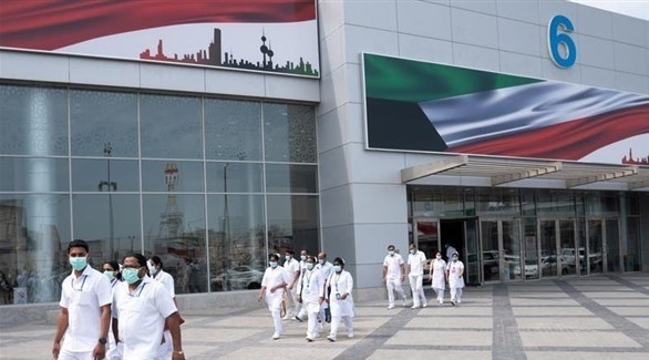 عاملون في القطاع الصحي الكويتي أمام أحد المستشفيات (أرشيف)