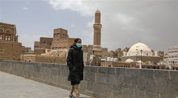 شخص يرتدي كمامة أثناء مروره في شوارع اليمن (أرشيف)