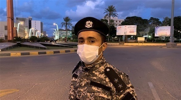 عنصر من الشرطة الليبية مرتدياً قناعاً للوجه (رويترز)