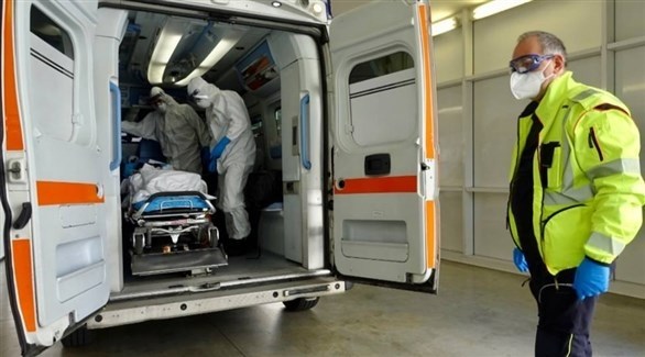 مسعفون مع مصاب بكورونا في سيارة إسعاف بإيطاليا (أرشيف)