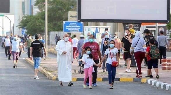 مواطنون ومقيمون يتجولون في شارع بالكويت مرتدين الكمامات (أرشيف)