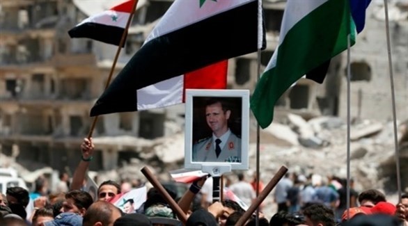 متظاهرون يرفعون صورة الرئيس السوري خلال إحدى التجمعات في سوريا (أرشيف)