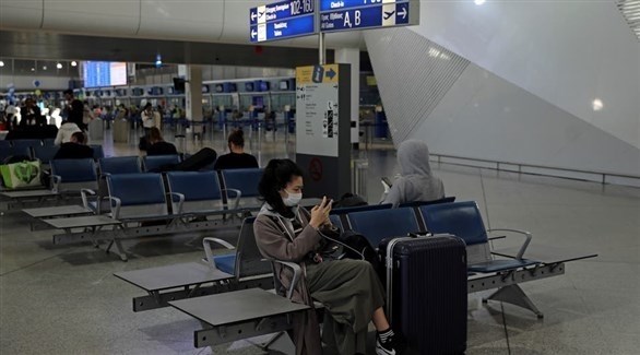 مسافرة في مطار أثينا تضع كمامة للوقاية من فيروس كورونا (أرشيف)