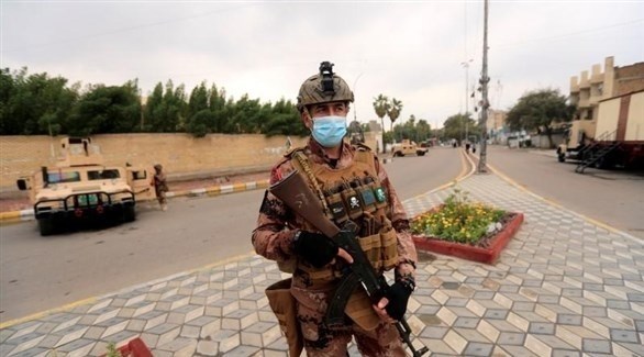 رجل أمن يضع كمامة صحية في بغداد (أرشيف)