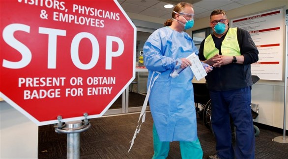 عاملان في القطاع الصحي الأمريكي أمام مدخل مستشفى في نيويوؤك (أرشيف)