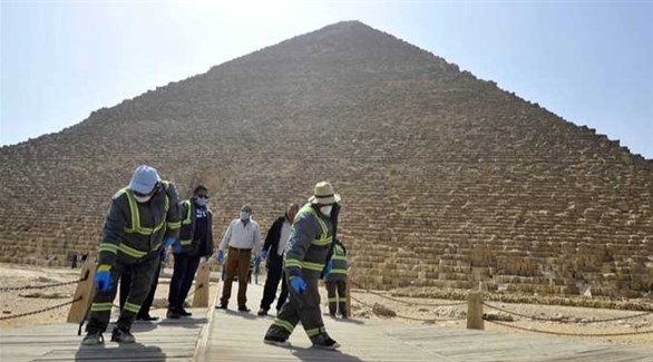 عمال مصريون يعقمون منطقة الهرم في الجيزة (أرشيف)