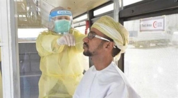 عامل بقطاع الصحة العماني يأخذ مسحة من عماني لفحص كورونا (أرشيف)