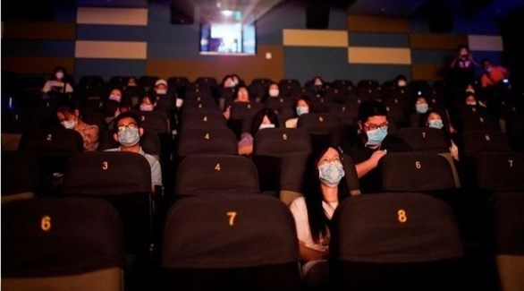 أشخاص يشاهدون فيلماً في قاعة سينما بشنغهاي (رويترز)