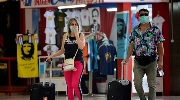 رجل وامرأة يرتديان الكمامة الصحية خوفاً من كورونا في كوبا (أرشيف)