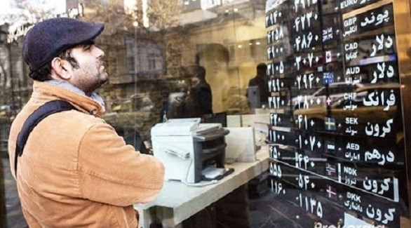 إيراني أمام لوحة بأسعار العملات الأجنبية (أرشيف)