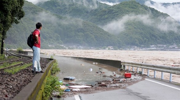 ياباني ينظر إلى تدفق المياه الجارفة بسبب الفيضانات (أرشيف)