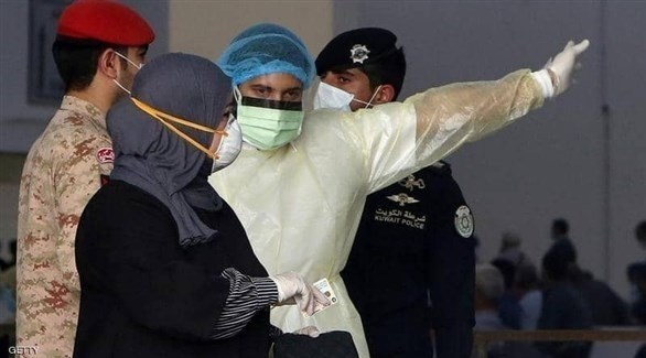 عامل في القطاع الصحي الكويتي يرشد سيدة في مركز فحص (أرشيف)