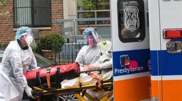 عاملان في القطاع الصحي الأمريكي ينقلان مصاباً بكورونا إلى سيارة إسعاف (أرشيف)
