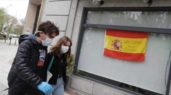 إسبانيان إلى جانب علم بلادهما في مدريد (أرشيف)