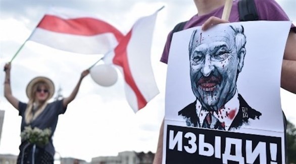 محتج يرفع صورة مشوهة لرئيس بيلاروس ألكسندر لوكاشينكو (أ ف ب)