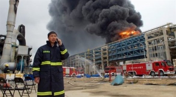 عامل إطفاء صيني أمام حريق في أحد المصانع (أرشيف)