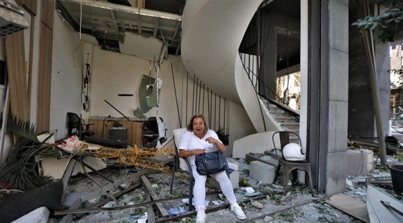 لبنانية تجلس على انقاض منزلها المهدم بسبب انفجار بيروت (إ ب أ)