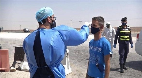 عامل في القطاع الصحي الأردني يفحص وافداً إلى المملكة على الحدود (أرشيف)