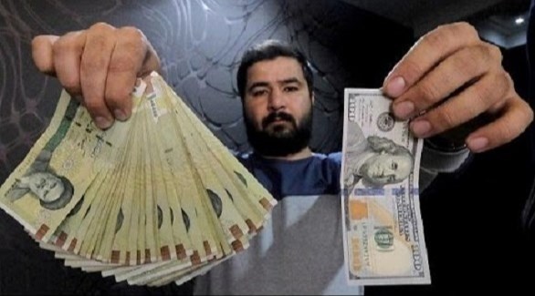 صراف إيراني يعرض ريالات إيرانية مقابل الدولار الأمريكي (أرشيف)