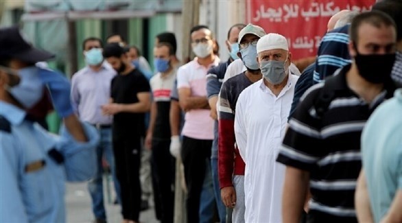 فلسطينيون أمام مركز لتوزيع اللقاحات المضادة لكورونا (أرشيف)