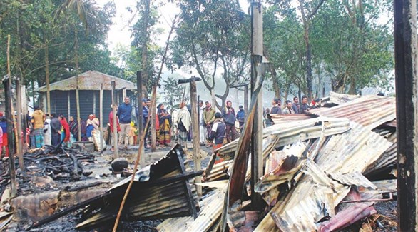 هندوس أمام ركام بيوتهم المحترقة في بنغلادش (تويتر)