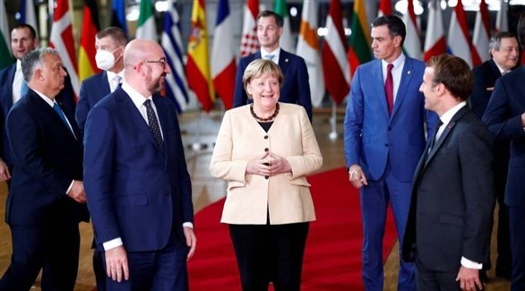 المستشارة الألمانية أنجيلا ميركل بين الرئيس الفرنسي إيمانويل ورئيس المجلس الأوروبي شارل ميشال (رويترز)
