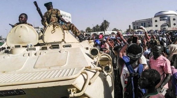 متظاهرون سودانيون حول مدرعة للجيش (أرشيف)