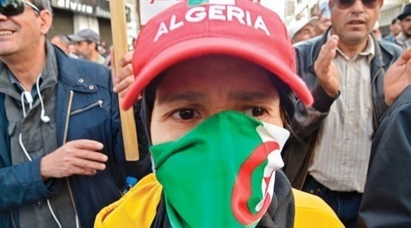 شخص يرتدي كمامة تحمل ألوان العلم الجزائري (أرشيف)