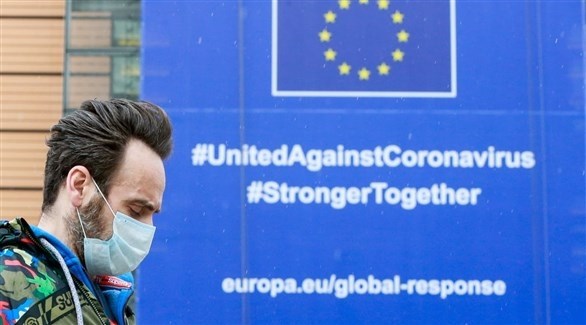 رجل أمام جدارية تدعو الدول الأوروبية للوحدة في مواجهة كورونا (أرشيف)