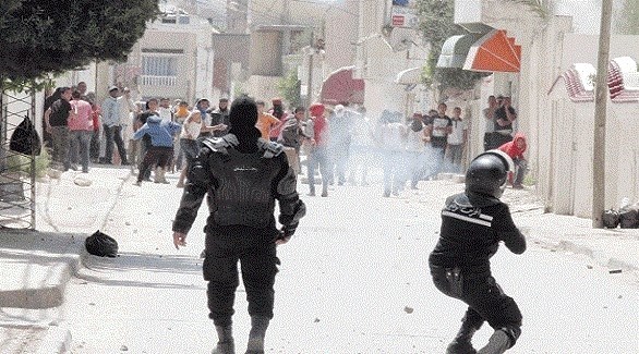 شرطي تونسي يطلق غازاً مسيلاً للدموع على متظاهرين (أرشيف)