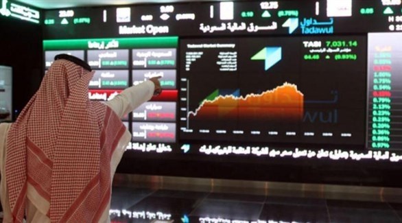 متداول أمام شاشة تعرض مؤشرات في سوق الأسهم السعودية (أرشيف)